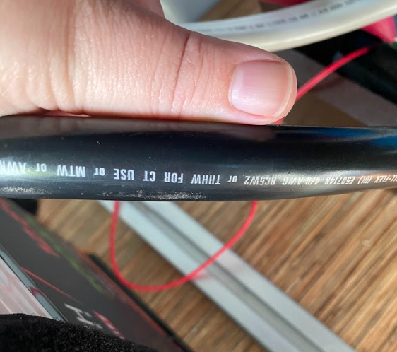 A thumb alongside a wire. They are similarly sized.