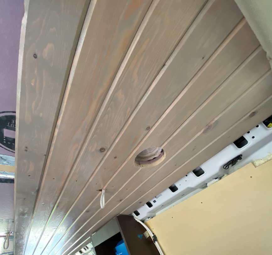 A closer view of the van ceiling, with more boards in place. They are shiny.