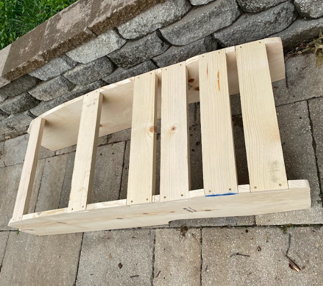 A cabinet frame, with a series of six horizontal pieces installed along the back for mounting.