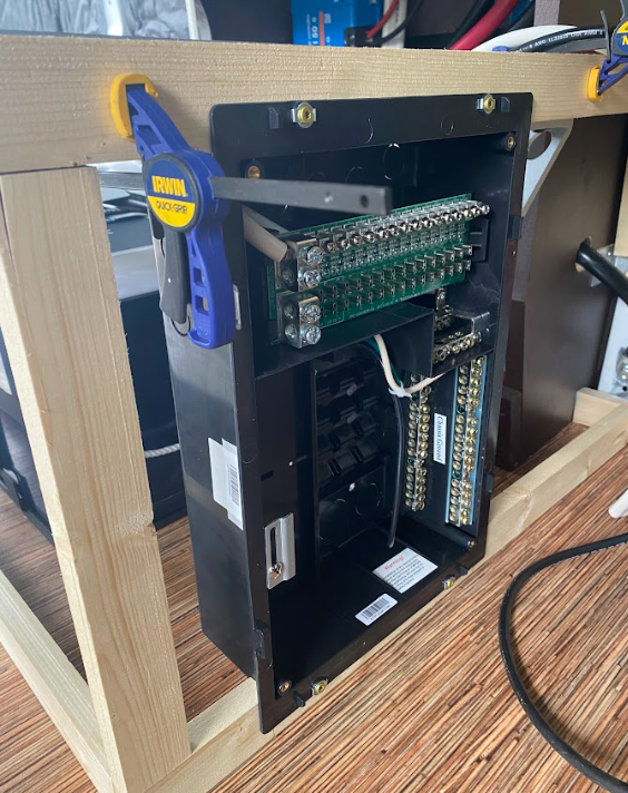 A close-up of the distribution panel screwed into the cabinet frame.