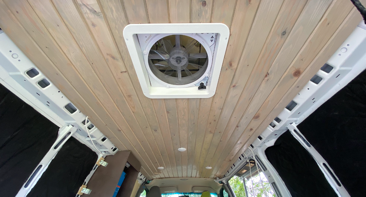 Interior of a cargo van, looking up from the rear doors at a tongue and groove wood ceiling.