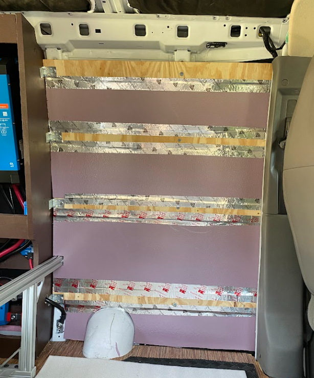 Pink foam insulation board between horizontal wood strips.