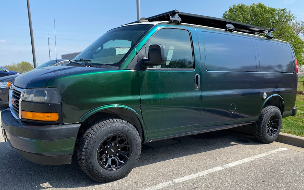 A photo of a cargo van with slightly knobby tires and solid black wheels.