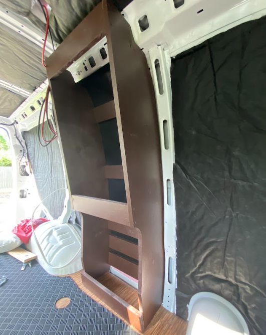 The cabinet frame from previous photos, painted a medium brown and placed in its location for a test fit.