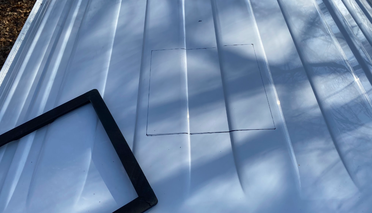 A white van roof with a square drawn on it in black. A black square frame sits beside the marking.