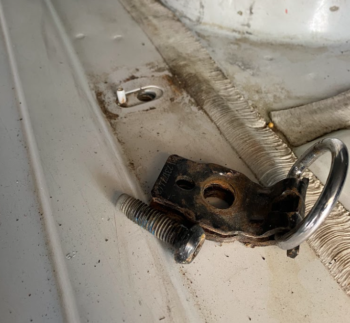 A bolt, a ring with a bolt hole attached, and a floor-hole that matches the bolt.