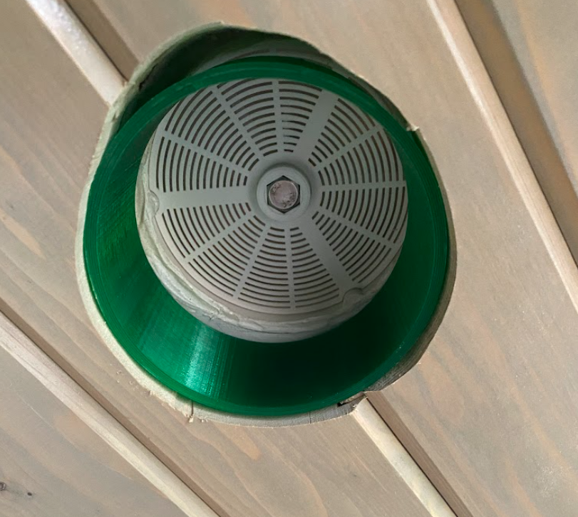 The green printed insert, installed in the vent hole.