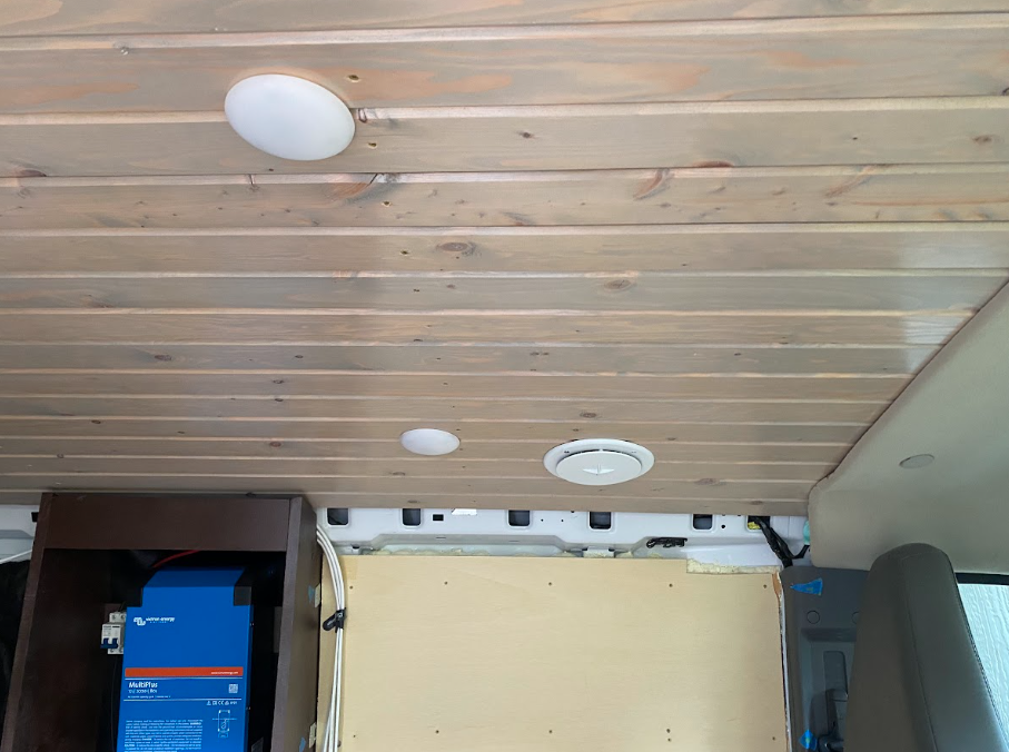 A view of the van ceiling from the side door, showing the installed vent cover in place.